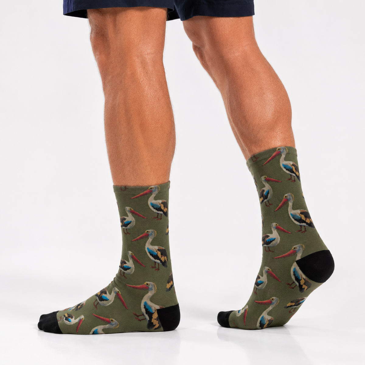 Green socks with pelican pattern worn by a person on a white background. Australian life style