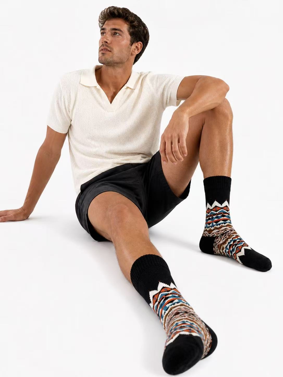 Man wearing patterned socks sitting on a white background. Scandinavian Style Socks for Men