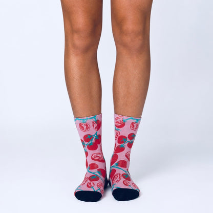 Colourful bamboo socks featuring a red cherry tomato design on a pink background.