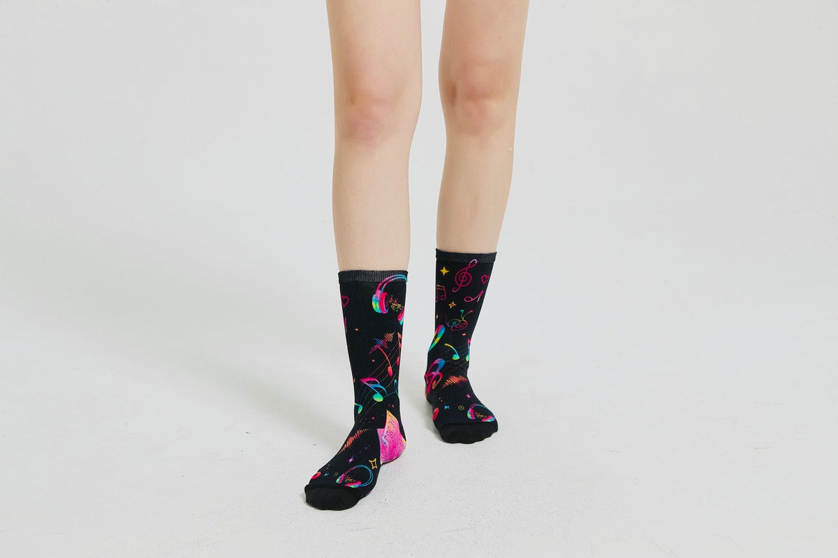 Colourful bamboo socks featuring rainbow music notes and headphones on a black background.