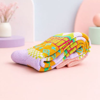 Colorful folded socks on a light pink surface with a blurred background. Scandinavian Style Socks