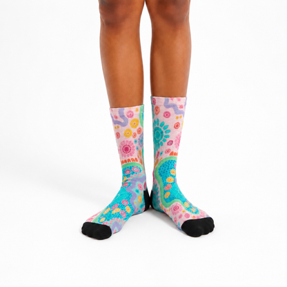 Colorful patterned socks worn by a person on a white background. aboriginal designs by Caitlin_Trindall