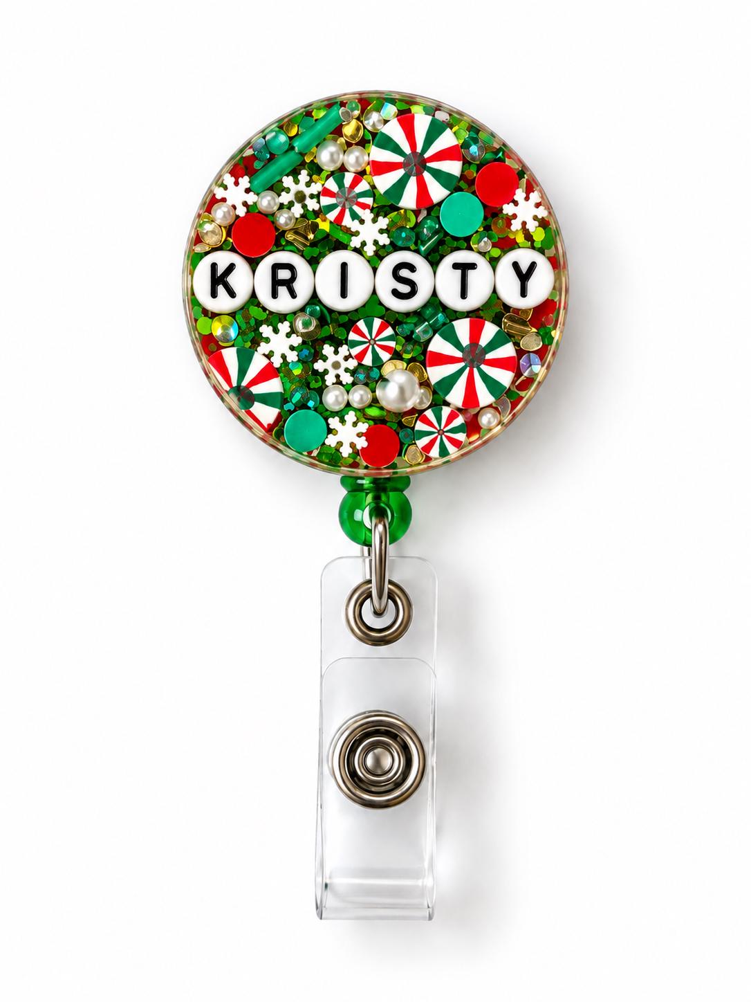 Green Christmas letter bead badge reel with the name Kristy in white letter beads