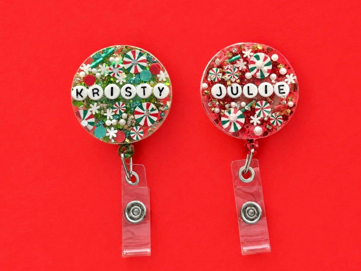 Kristy and Julie personalised Christmas letter bead badge reels on a red background