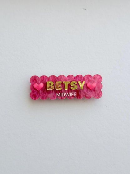 Pink scalloped Christmas name badge with hearts reading Betsy, Midwife