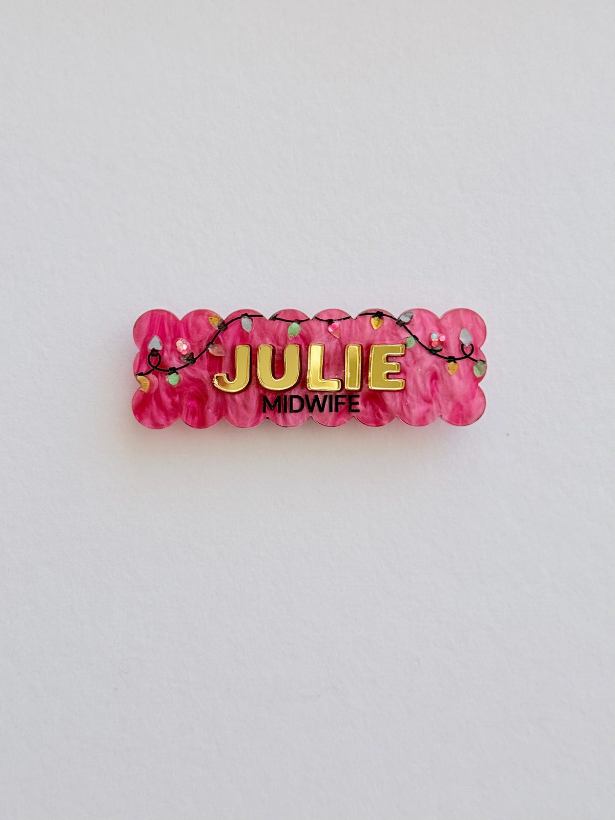 Pink scalloped Christmas lights name badge reading Julie, Midwife